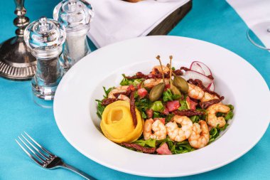 Akdeniz salatası. Arugula, domates, karides, zeytin, zeytin, fesleğen ve biberiye, zeytinyağı ve balsamik sos ile giyinmiş, limon ve biber biber ile süslenmiş