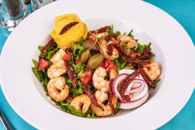 Akdeniz salatası. Arugula, domates, karides, zeytin, zeytin, fesleğen ve biberiye, zeytinyağı ve balsamik sos ile giyinmiş, limon ve biber biber ile süslenmiş