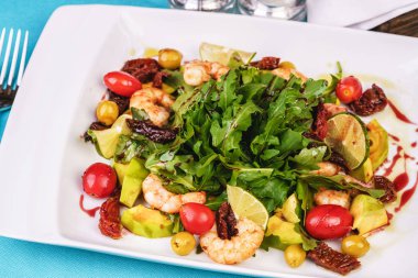 Izgara karides, kiraz domates, arugula, yeşillik, avokado, limon, zeytin, balsamik sos ile Akdeniz salatası