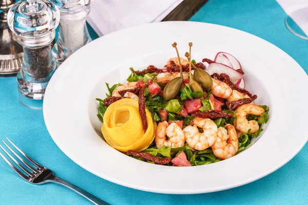 Akdeniz salatası. Arugula, domates, karides, zeytin, zeytin, fesleğen ve biberiye, zeytinyağı ve balsamik sos ile giyinmiş, limon ve biber biber ile süslenmiş