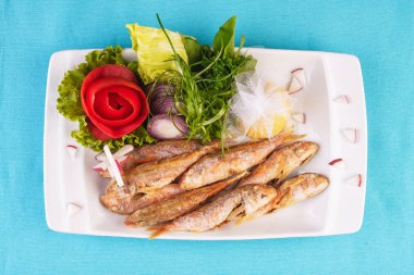 Akdeniz yemeği, Avrupa mutfağı. Bütün balık ızgara capelin, sebze yeşillik, arugula, soğan halkaları, domates, yeşil ve sarı biber ve limon bir salata ile servis