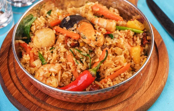 Mediterranean dish, European cuisine. The dish is from Uzbek cuisine.Rice fried with vegetables - greens, carrots, red pepper, onions and seafood - shrimps, mussels and squid.