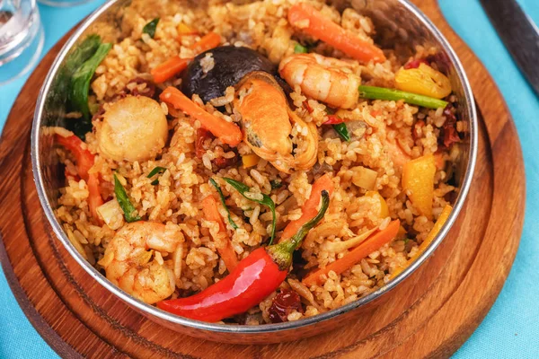 Mediterranean dish, European cuisine. The dish is from Uzbek cuisine.Rice fried with vegetables - greens, carrots, red pepper, onions and seafood - shrimps, mussels and squid.