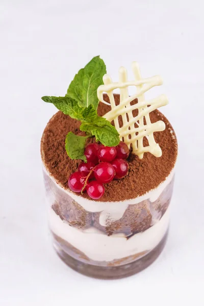 European dessert, national cuisine. Tiramisu. chocolate and cream mousse, served with red smarodina in a glass, sprinkled with cocoa