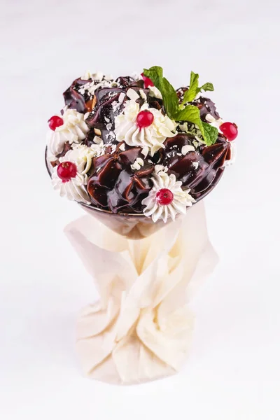 European dessert, national cuisine. Dessert from meringue, poured chocolate, with cream flowers and berries.