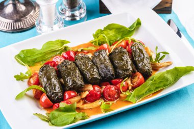 Özbek mutfağı, oryantal mutfağı. Dolma - Üzüm yaprakları, et, sığır eti ve pirinç ile haşlanmış rulo. Sebze ile servis - domates, biber, salatalık ve soğan