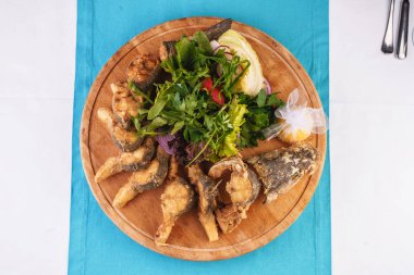 Deniz ürünleri, Akdeniz mutfağı. Fırında patates, soğan halkaları, biber, limon ve yeşillik ile balık. Kafkas mutfağı