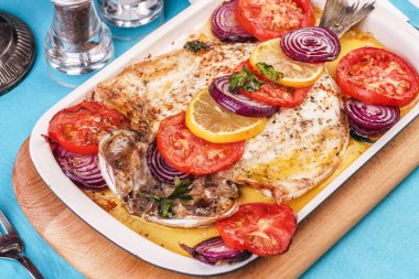 Deniz ürünleri, Akdeniz mutfağı, Avrupa yemeği. Kokulu baharatlar altında soğan halkaları, pimodori, kabak ve baclazans ile folyo balık tamamen pişmiş. Kafkas ulusal mutfağı