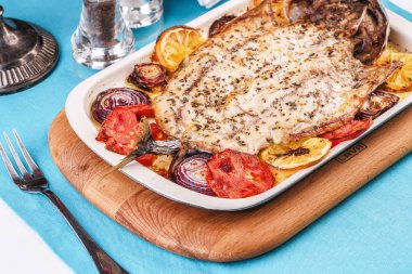 Deniz ürünleri, Akdeniz mutfağı, Avrupa yemeği. Kokulu baharatlar altında soğan halkaları, pimodori, kabak ve baclazans ile folyo balık tamamen pişmiş. Kafkas ulusal mutfağı