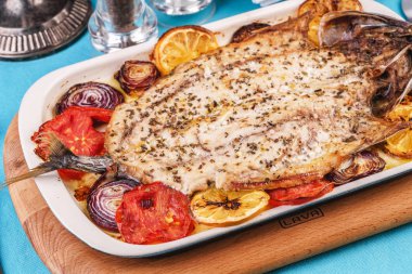 Deniz ürünleri, Akdeniz mutfağı, Avrupa yemeği. Kokulu baharatlar altında soğan halkaları, pimodori, kabak ve baclazans ile folyo balık tamamen pişmiş. Kafkas ulusal mutfağı