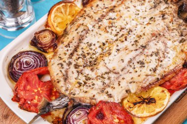 Deniz ürünleri, Akdeniz mutfağı, Avrupa yemeği. Kokulu baharatlar altında soğan halkaları, pimodori, kabak ve baclazans ile folyo balık tamamen pişmiş. Kafkas ulusal mutfağı