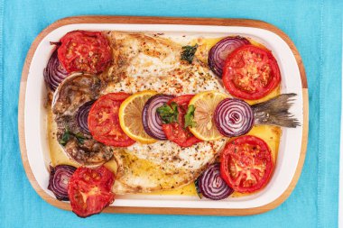 Deniz ürünleri, Akdeniz mutfağı, Avrupa yemeği. Kokulu baharatlar altında soğan halkaları, pimodori, kabak ve baclazans ile folyo balık tamamen pişmiş. Kafkas ulusal mutfağı