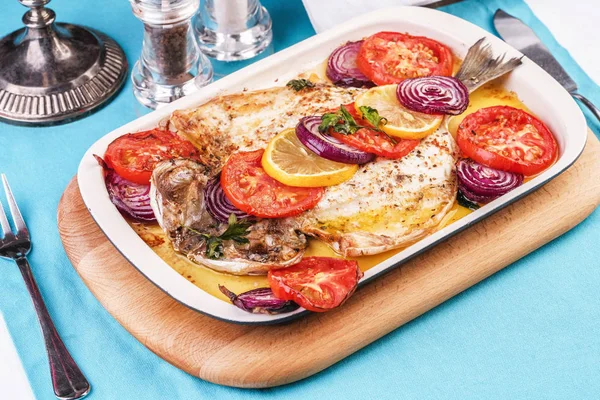 Deniz ürünleri, Akdeniz mutfağı, Avrupa yemeği. Kokulu baharatlar altında soğan halkaları, pimodori, kabak ve baclazans ile folyo balık tamamen pişmiş. Kafkas ulusal mutfağı