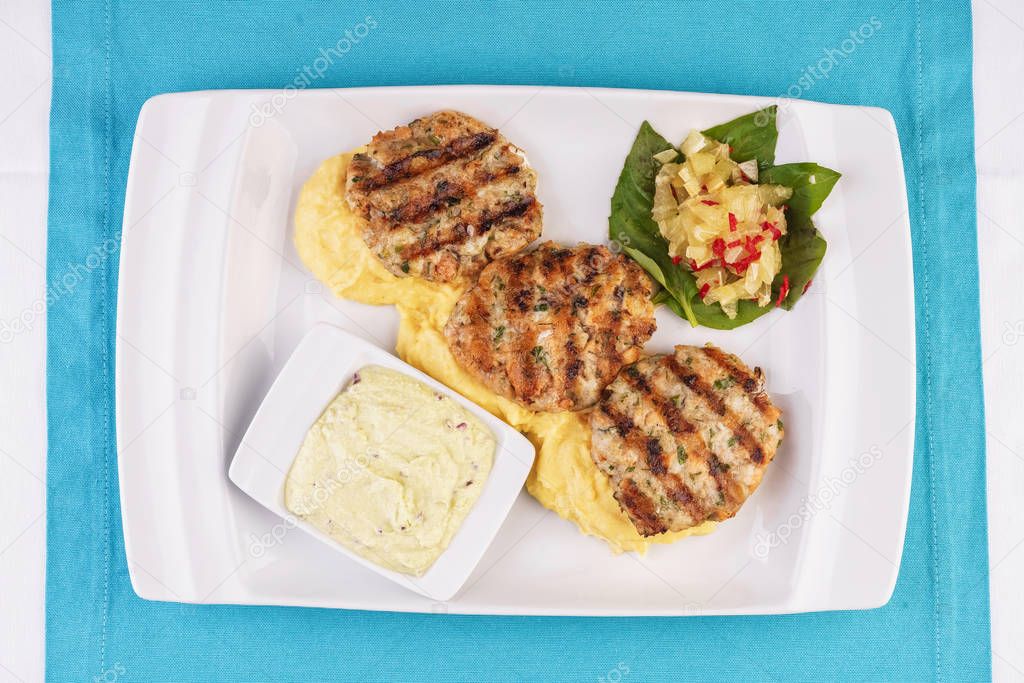 Fried fish patties served with vegetables, salad and greens and mashed potatoes according to Georgian recipe