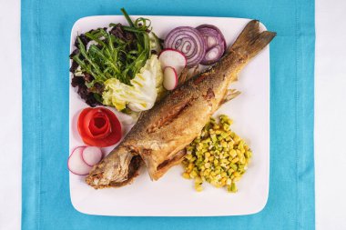 Gürcü tarifine göre sebze, salata ve yeşillikile servis edilen kızarmış balık