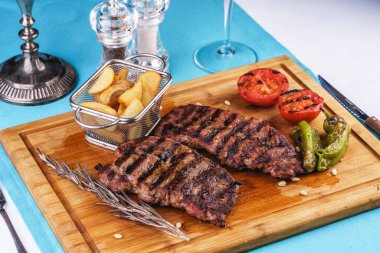 ızgara biber, soğan halkaları ve domates ile ızgara sığır biftek. patates dilimleri ve kekik ile servis edilir. Gürcü tarifine göre