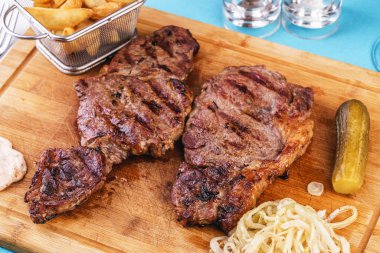 ızgara biber, soğan halkaları ve domates ile ızgara sığır biftek. patates dilimleri ve kekik ile servis edilir. Gürcü tarifine göre