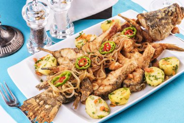 Deniz ürünleri, Akdeniz mutfağı. Fırında patates, soğan halkaları, biber, limon ve yeşillik ile balık. Kafkas mutfağı