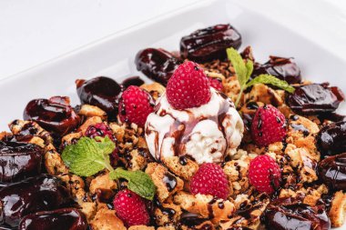 Kremalı dondurma, ahududu, nane, çikolata sosu ve tarihleri ile Berry çikolatalı kek