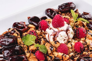 Kremalı dondurma, ahududu, nane, çikolata sosu ve tarihleri ile Berry çikolatalı kek