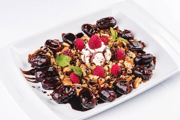 Kremalı dondurma, ahududu, nane, çikolata sosu ve tarihleri ile Berry çikolatalı kek