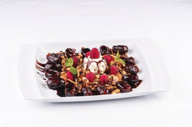 Kremalı dondurma, ahududu, nane, çikolata sosu ve tarihleri ile Berry çikolatalı kek