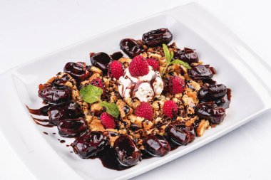 Kremalı dondurma, ahududu, nane, çikolata sosu ve tarihleri ile Berry çikolatalı kek