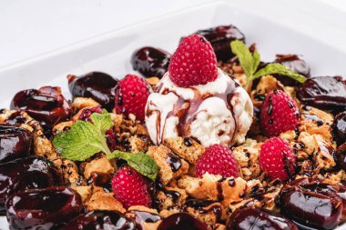 Kremalı dondurma, ahududu, nane, çikolata sosu ve tarihleri ile Berry çikolatalı kek