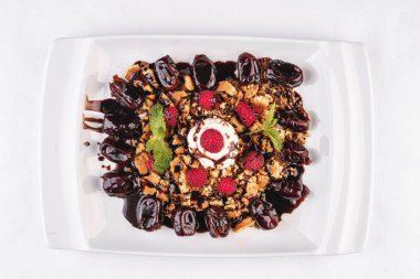 Kremalı dondurma, ahududu, nane, çikolata sosu ve tarihleri ile Berry çikolatalı kek