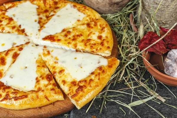 Georgian national dish with cheese, butter and herbs - khachapuri. Baked diced dough with spices and cheese, appetizer in Georgian style. National cuisine