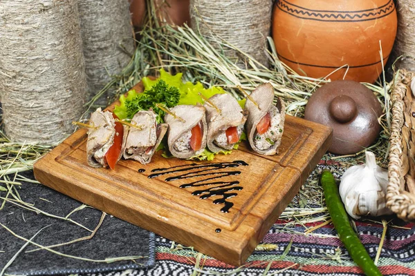 Meat rolls of horse meat with tomato and stuffing, with greens and tomatoes according to the Eastern recipe