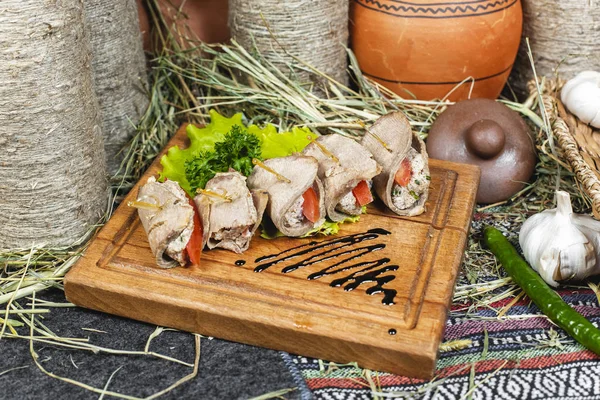 Meat rolls of horse meat with tomato and stuffing, with greens and tomatoes according to the Eastern recipe