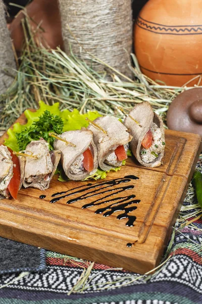 Meat rolls of horse meat with tomato and stuffing, with greens and tomatoes according to the Eastern recipe