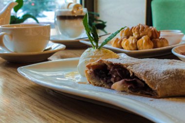 strudel kek - hamur kiraz ve reçel ile doldurulmuş, vanilyalı dondurma ve nane yaprakları bir kepçe ile servis edilir. Profitero kek - muhallebi dolgulu hava pasta. Marshmallowlu kahve. Avrupa tarifi.