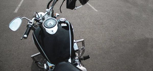 Elegante motocicleta brillante negro con acentos cromados en los espejos. Un helicóptero estacionado sobre un fondo de asfalto gris . — Foto de Stock