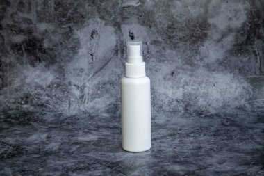 Gri arka planda beyaz plastik sprey sprey dezenfektan. yan görünüm