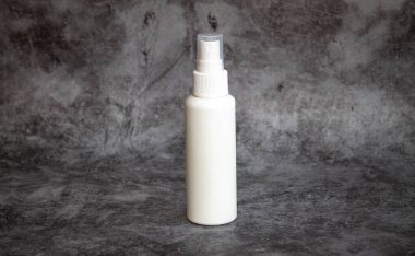 Gri arka planda beyaz plastik sprey sprey dezenfektan. yan görünüm