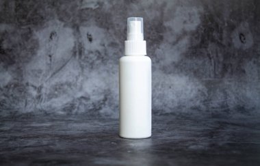 Gri arka planda beyaz plastik sprey sprey dezenfektan. yan görünüm