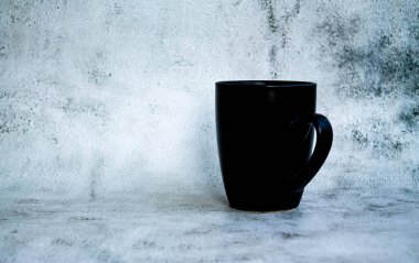 Gri arka planda kahve için siyah fincan. yan görünüm