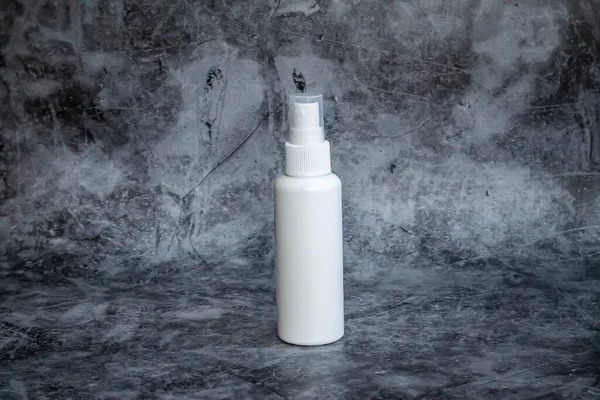 Gri arka planda beyaz plastik sprey sprey dezenfektan. yan görünüm