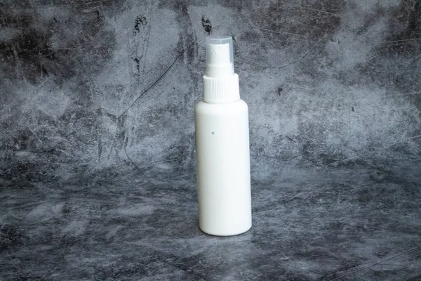 Gri arka planda beyaz plastik sprey sprey dezenfektan. yan görünüm