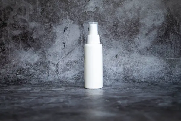 Gri arka planda beyaz plastik sprey sprey dezenfektan. yan görünüm