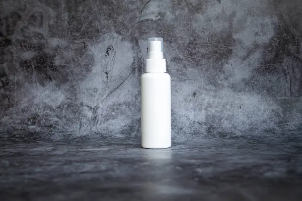 Gri arka planda beyaz plastik sprey sprey dezenfektan. yan görünüm