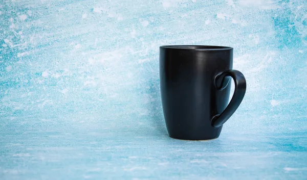 Taza negra para café sobre fondo azul. vista lateral — Foto de Stock