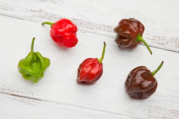 Cinque Interi Freschi Peperoncini Trinidad Scorpion Sfondo Dipinto Bianco — Foto Stock