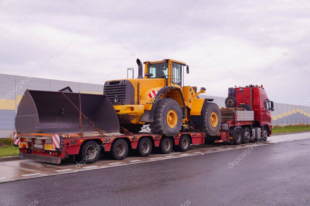 A truck with a special semi-trailer for transporting oversized loads. Transport of a huge bulldozer.