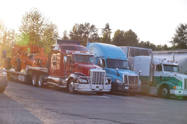 A row of trucks. End of the day, the setting sun. Truck stop.