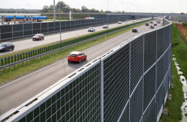 High sound-absorbing barriers separating the highway from the residential area. Also known as absorbing panels, soundbars, noise barriers etc. clipart