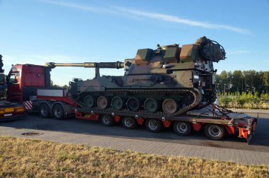 Standart dışı, alışılmadık yol ulaşımı. Tank şasesine bir havan topu. Olağanüstü bir konvoy. Uzun araç.