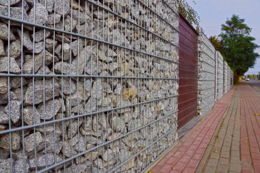 Gabionlar. Gabiyonlardan yapılmış bir çit parçası. Caddenin yerleşim alanlarından ayrılması.
